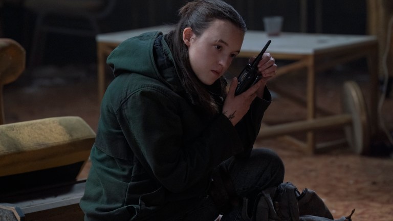 Ellie (Bella Ramsey) listens to a walkie talkie in The Last of Us season 2